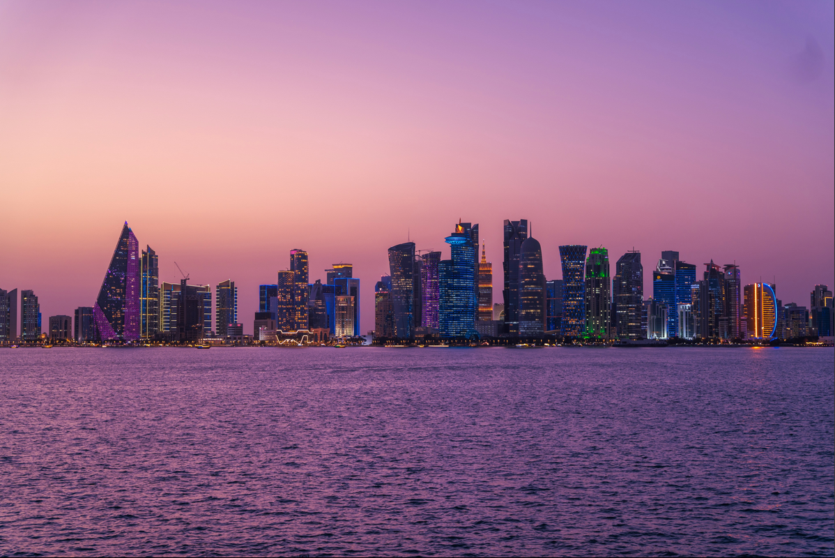 Doha skyline reflected across the water at sunset